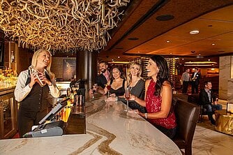 a group of women sitting at a bar