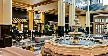 a large room with a fountain and tables