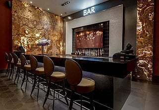 a bar with stools and a bar behind it