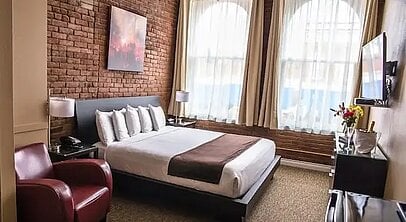 a bedroom with a bed and a chair